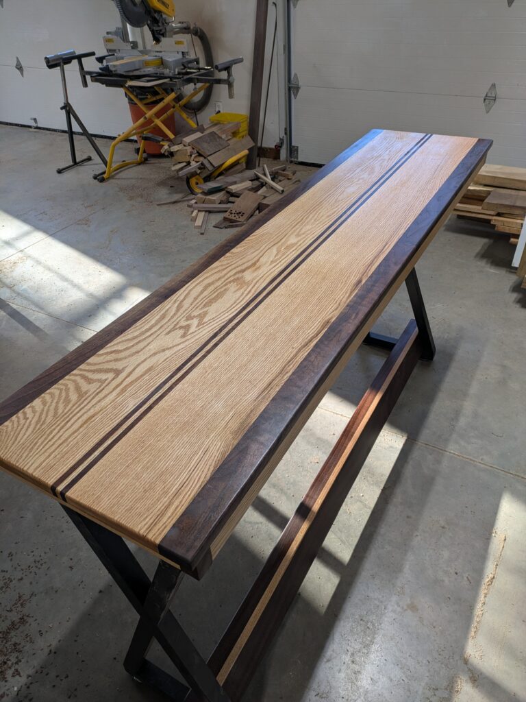 Oak and black walnut high table used as a bar stool counter.